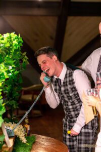 A young male guest burst out laughing after listening to the audio message on the audio guest book