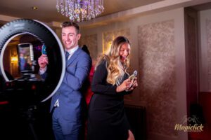 A lovely couple at a wedding, prom or party posing for photos on the 360 using props and sign boards