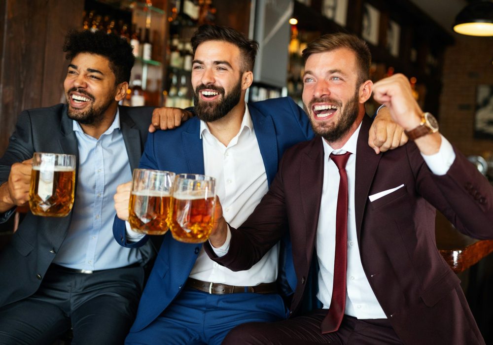 Business men in pub cheering for a sporting event